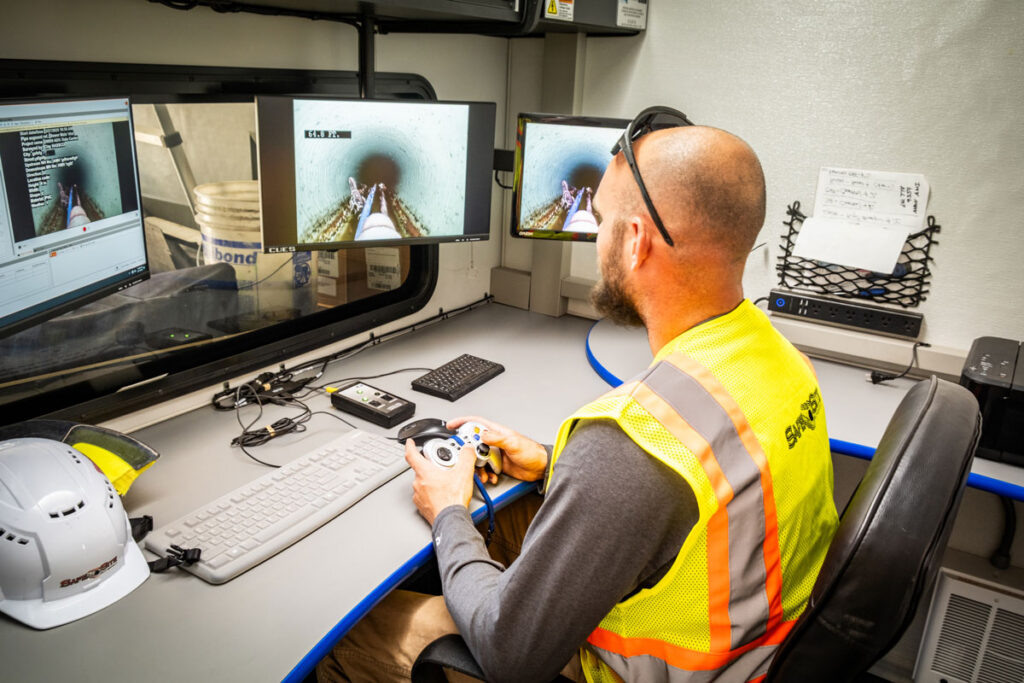man looking the monitor to see the if the pipeline is damage thanks to be robot camera