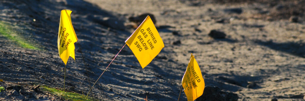 yellow flags on the ground showing gas lines buried underground